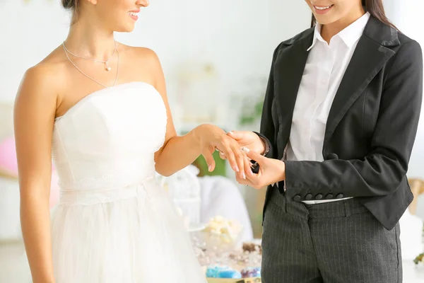 Jovem casal lésbico trocando anéis durante a cerimônia de casamento — Fotografia de Stock