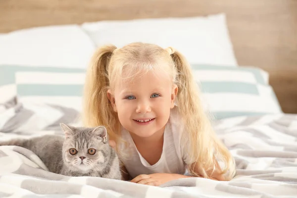 Μικρό κορίτσι με χαριτωμένο γάτα στο υπνοδωμάτιο — Φωτογραφία Αρχείου