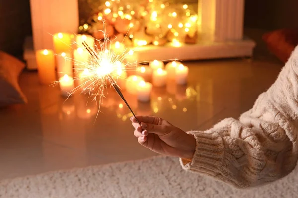 Young woman with Christmas sparklers in room — Stock Photo, Image
