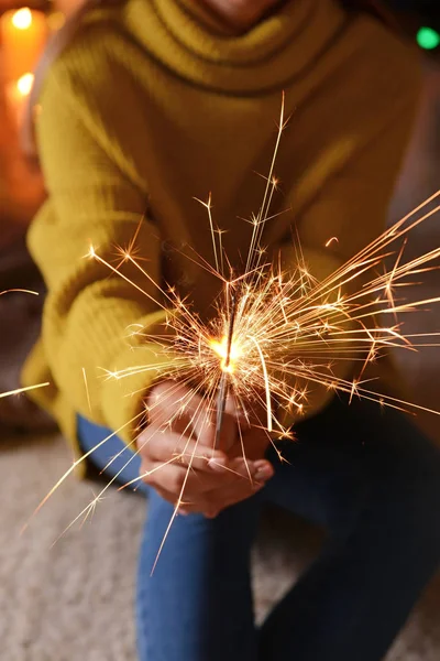 Young woman with Christmas sparklers sitting in room, closeup — Stock Photo, Image