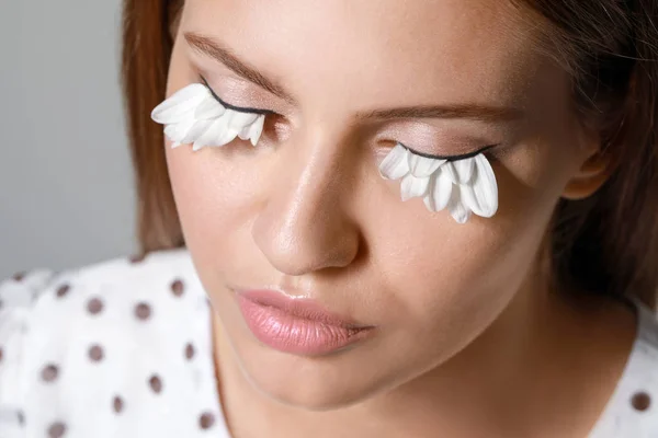 Young woman with creative eyelashes on grey background, closeup — Stock Photo, Image