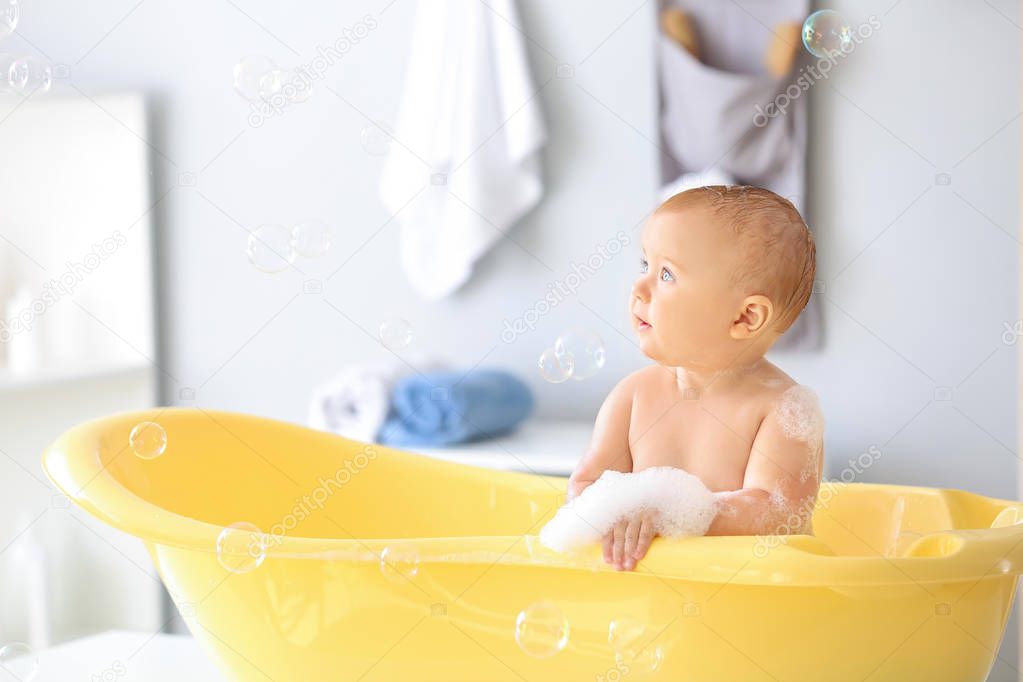 Cute little baby in bathtub at home