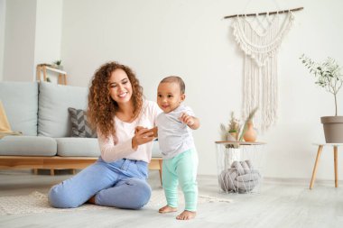 Afro-Amerikalı anne evde yürümek için küçük bebek öğretiyor