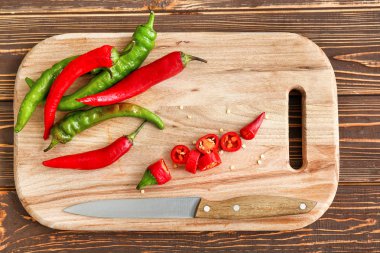 Ahşap kesme tahtası üzerinde acı biber ve bıçak