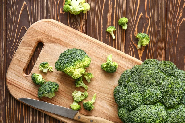Tagliere con cavolo broccolo fresco e coltello sul tavolo di legno — Foto Stock