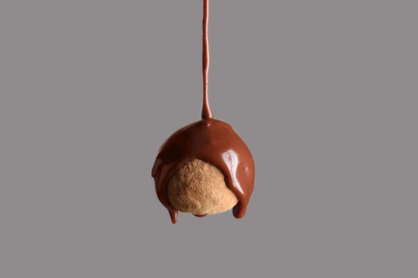 Despejo de chocolate em doces de trufa contra fundo cinza — Fotografia de Stock