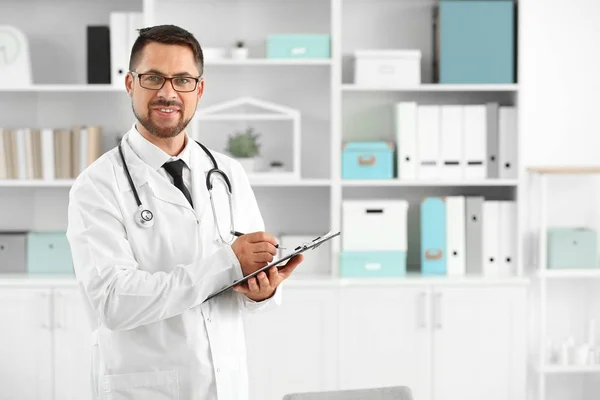 Portret van de mannelijke arts met Klembord in kliniek — Stockfoto
