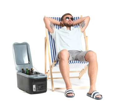 Yakışıklı genç adam beyaz arka plan karşı şezlong üzerinde rahatlatıcı