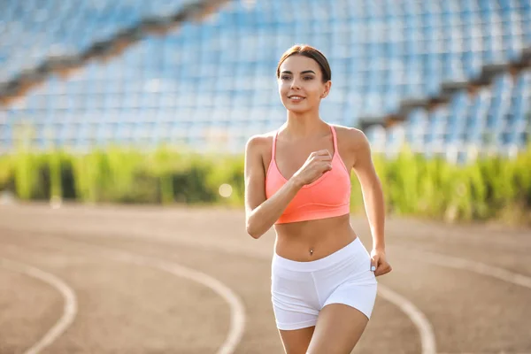 Sporty young woman running at the stadium — Stock Photo, Image