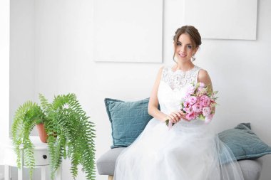 Evde düğün töreni öncesi buket ile güzel genç gelin