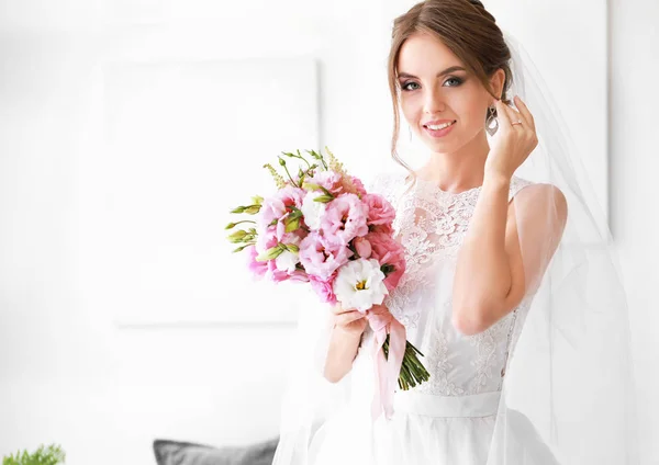 Beautiful young bride with bouquet before wedding ceremony at home — Stock Photo, Image