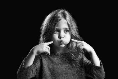 Koyu arka plan üzerinde grimacing küçük kız siyah beyaz portre