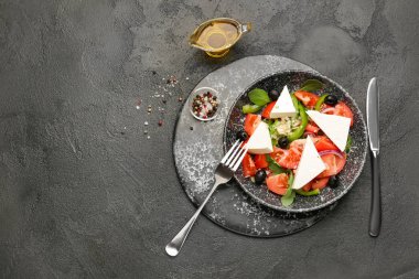 Koyu arka planda lezzetli Yunan salatası ile Tabak