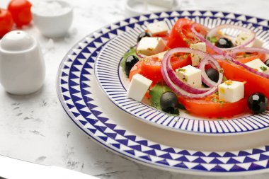 Plate with tasty Greek salad on table, closeup clipart