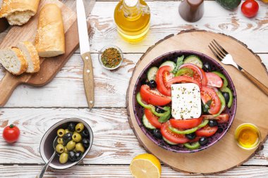 Plate with tasty Greek salad on wooden table clipart