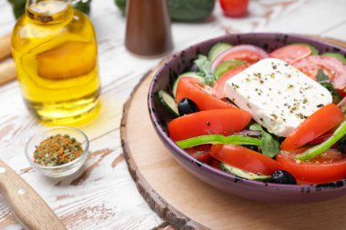 Plate with tasty Greek salad on table clipart