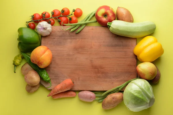 Board with many healthy vegetables and fruits on color background — Stock Photo, Image