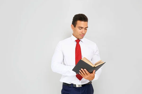 Bonito empresário afro-americano com livro sobre fundo branco — Fotografia de Stock