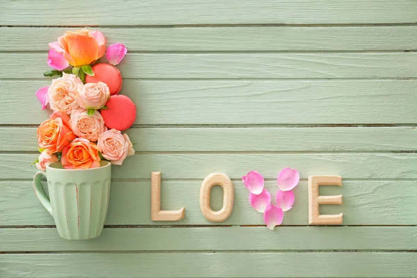 Schöne Komposition mit Rosenblüten und Tasse auf Holzgrund — Stockfoto