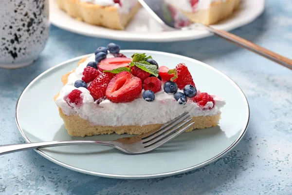 Teller mit Scheibe leckerer Beerenkuchen auf farbigem Hintergrund — Stockfoto