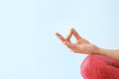 Genç bir kadın renkli arka plan üzerinde meditasyon yapıyor.