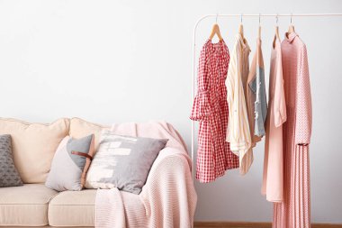 Soyunma odasında temiz kadın giysileri ve kanepe ile Raf