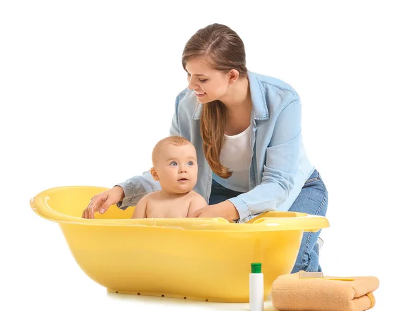 Mãe banho seu bebê pequeno bonito no fundo branco — Fotografia de Stock