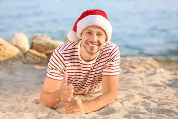 Gelukkige man in de kerstmuts met duim-up bij Tropical Resort — Stockfoto