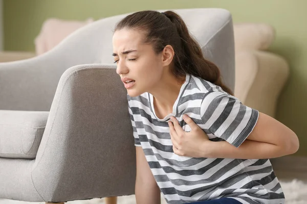Young woman suffering from heart attack at home — Stock Photo, Image