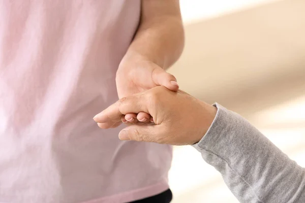 Young woman holding hand of her grandmother, closeup. Concept of care and support — Stock Photo, Image