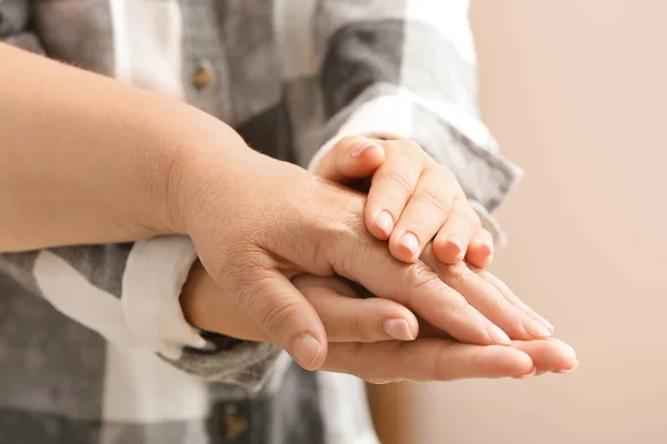 Mujer joven cogida de la mano de su abuela, de cerca. Concepto de cuidado y apoyo — Foto de Stock