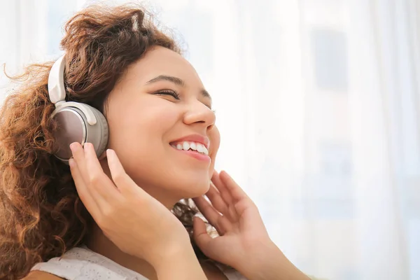 Belle jeune femme qui écoute de la musique à la maison — Photo