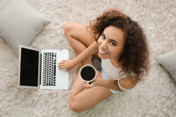 Krásná mladá žena s notebookem a šálek kávy doma — Stock fotografie