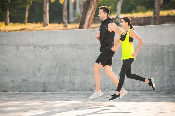 Sporty young couple running outdoors — Stock Photo, Image