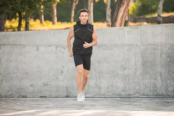 Sporty young man running outdoors — Stock Photo, Image