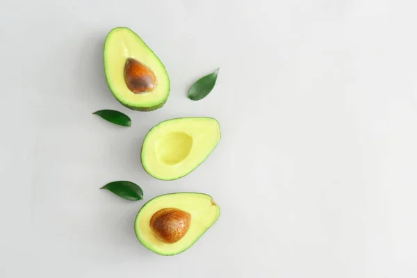 Helften van rijpe avocado op witte achtergrond — Stockfoto