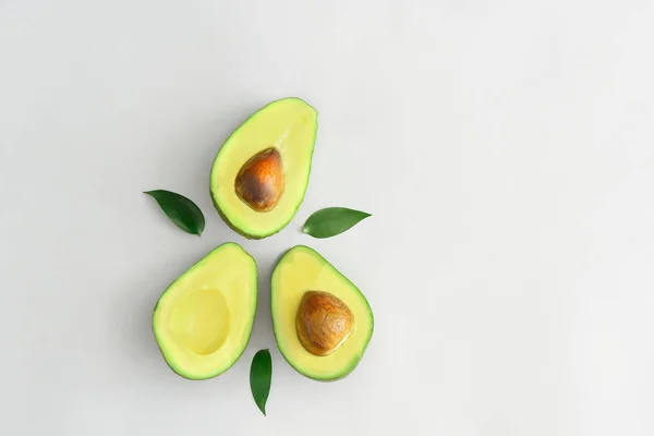 Halves of ripe avocado on white background — Stock Photo, Image