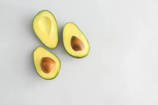 Helften van rijpe avocado op witte achtergrond — Stockfoto