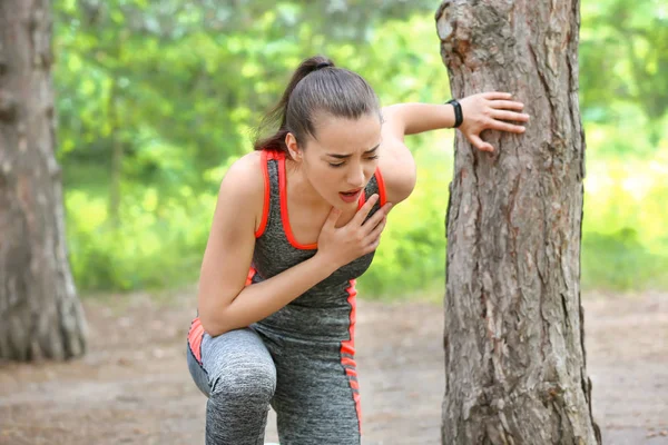 Sporty young woman suffering from heart attack outdoors — Stock Photo, Image