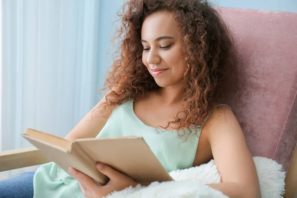 Mooie jonge vrouw die thuis boek leest — Stockfoto