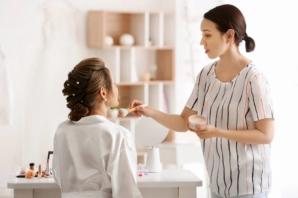 Truccatore professionista che lavora con la giovane sposa a casa — Foto Stock