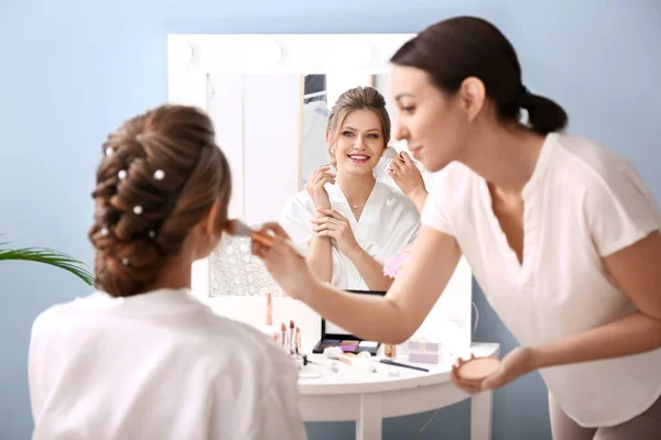 Truccatore professionista che lavora con la giovane sposa a casa — Foto Stock