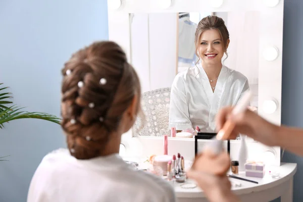 Profesionální make-up umělec pracující s mladou nevěstou doma — Stock fotografie
