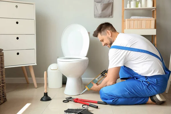 Rörmokare installera toalett i toaletten — Stockfoto