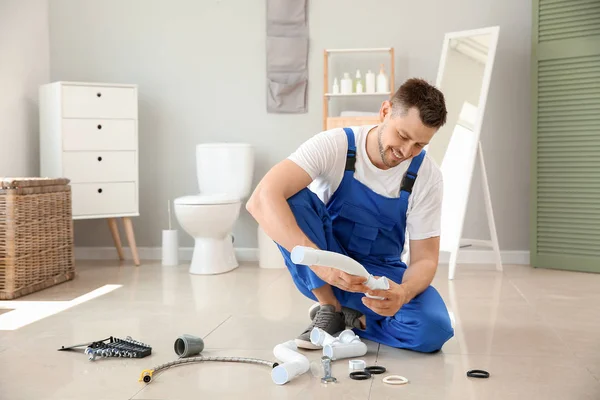 Snygg rörmokare arbetar i toaletten — Stockfoto