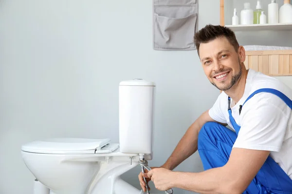 Plumber installing toilet in restroom — Stock Photo, Image