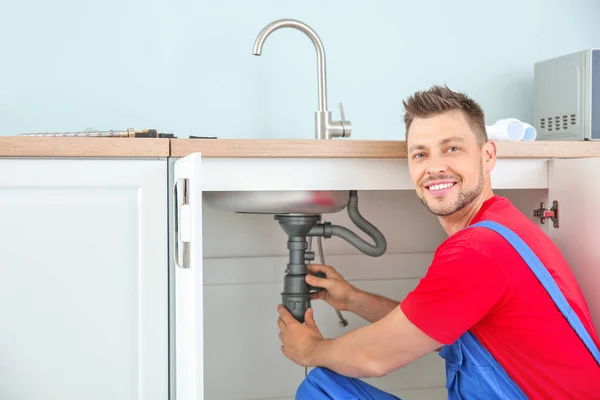 Encanador instalando pia na cozinha — Fotografia de Stock