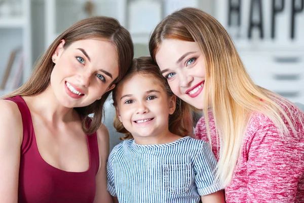 Happy lesbian couple with little daughter at home — Stock Photo, Image