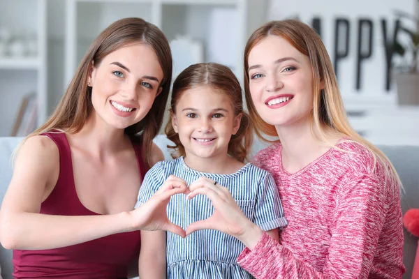 Happy lesbian couple with little daughter at home — Stock Photo, Image