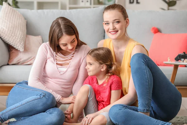 Happy lesbian couple with little daughter at home — Stock Photo, Image